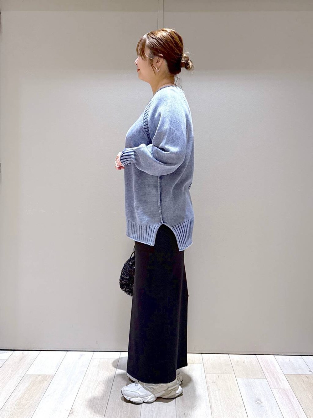 ブラック系のショルダーバッグ、ブラック系のスカート、ブルー系のニット/セーターを着用したレディースの冬コーディネートの4枚目の写真