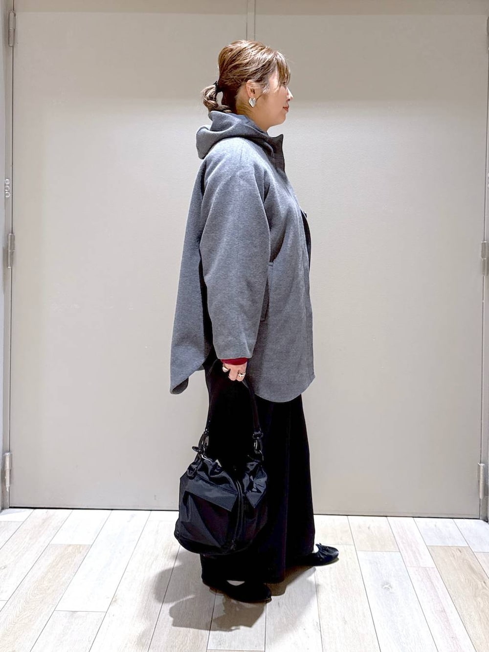 ブラック系のショルダーバッグ、グレー系のポンチョ、ブラック系のその他パンツを着用したレディースの冬コーディネートの2枚目の写真