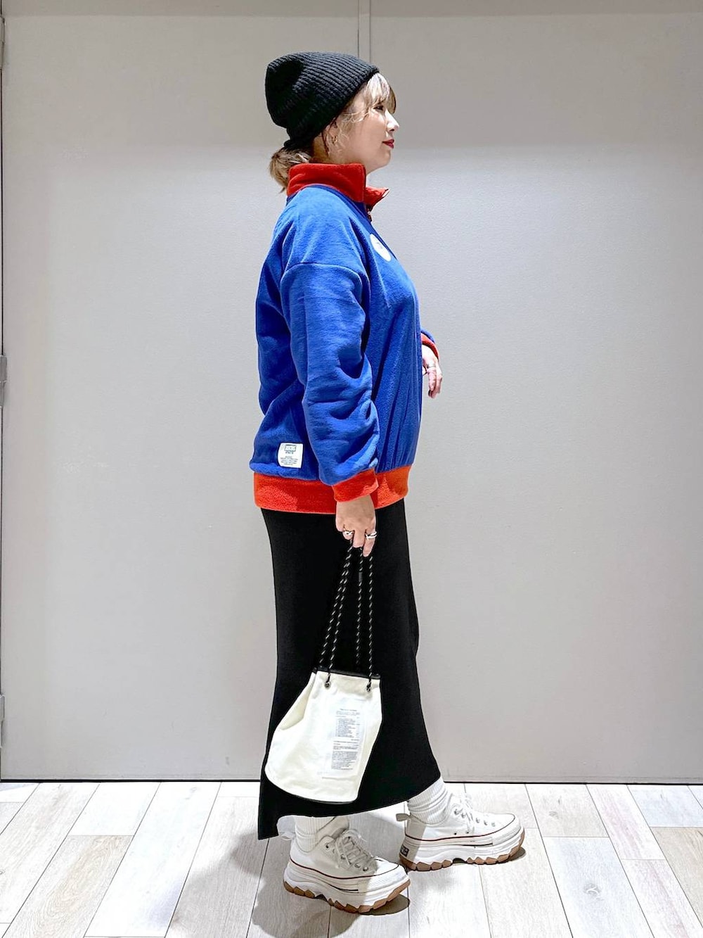 ブラック系のスカート、ブルー系のTシャツ/カットソー、ブラック系のニットキャップ/ビーニーを着用したレディースの秋コーディネートの2枚目の写真