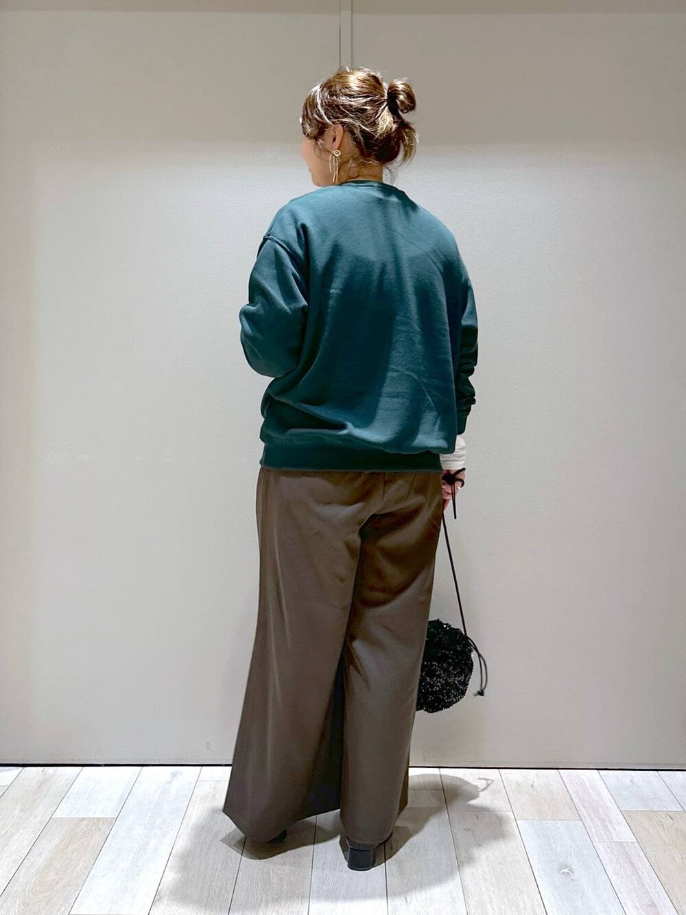 ブラック系のショルダーバッグ、ホワイト系のTシャツ/カットソー、ブラック系のブーツを着用したレディースの秋コーディネートの3枚目の写真