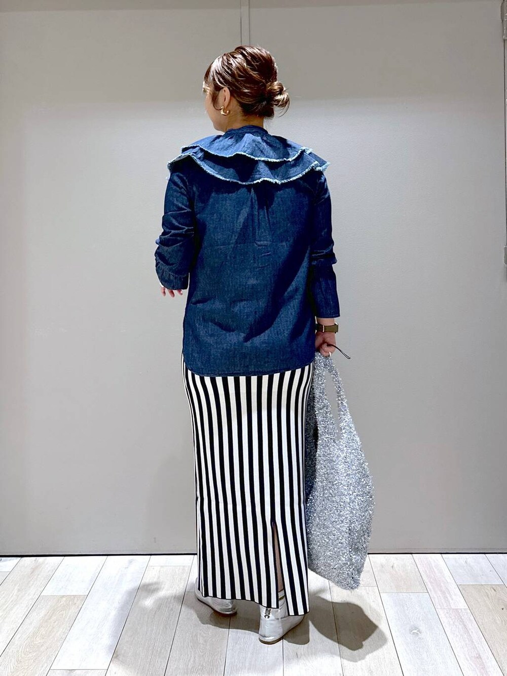 シルバー系のショルダーバッグ、シルバー系のパンプス、ブラック系のスカートを着用したレディースの秋コーディネートの3枚目の写真