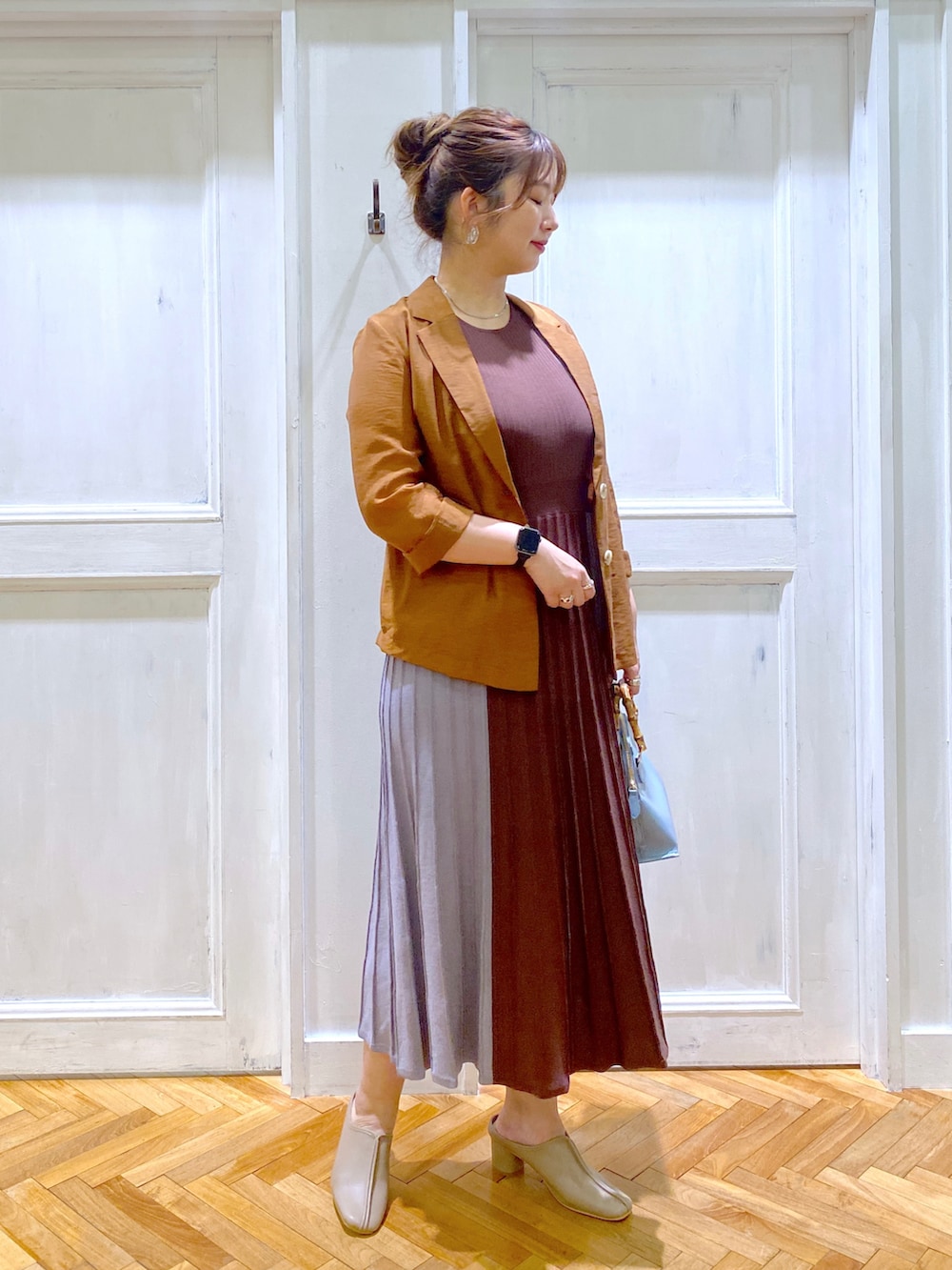 ブラウン系のテーラードジャケット、ブルー系のワンピース、ブルー系のショルダーバッグを着用したレディースの夏コーディネートの2枚目の写真