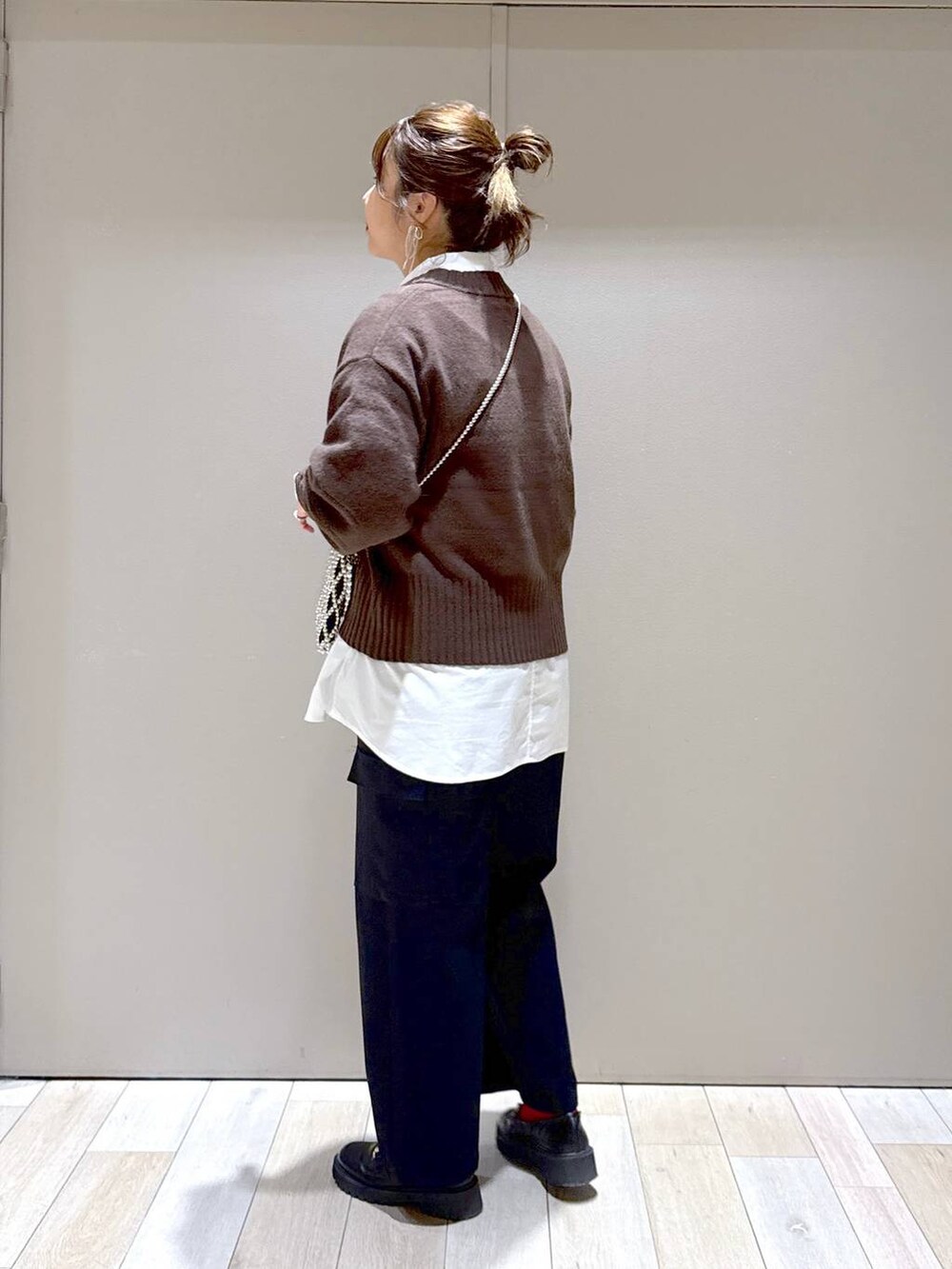 ブラウン系のニット/セーター、ブラック系のローファー、ホワイト系のシャツ/ブラウスを着用したレディースの冬コーディネートの4枚目の写真