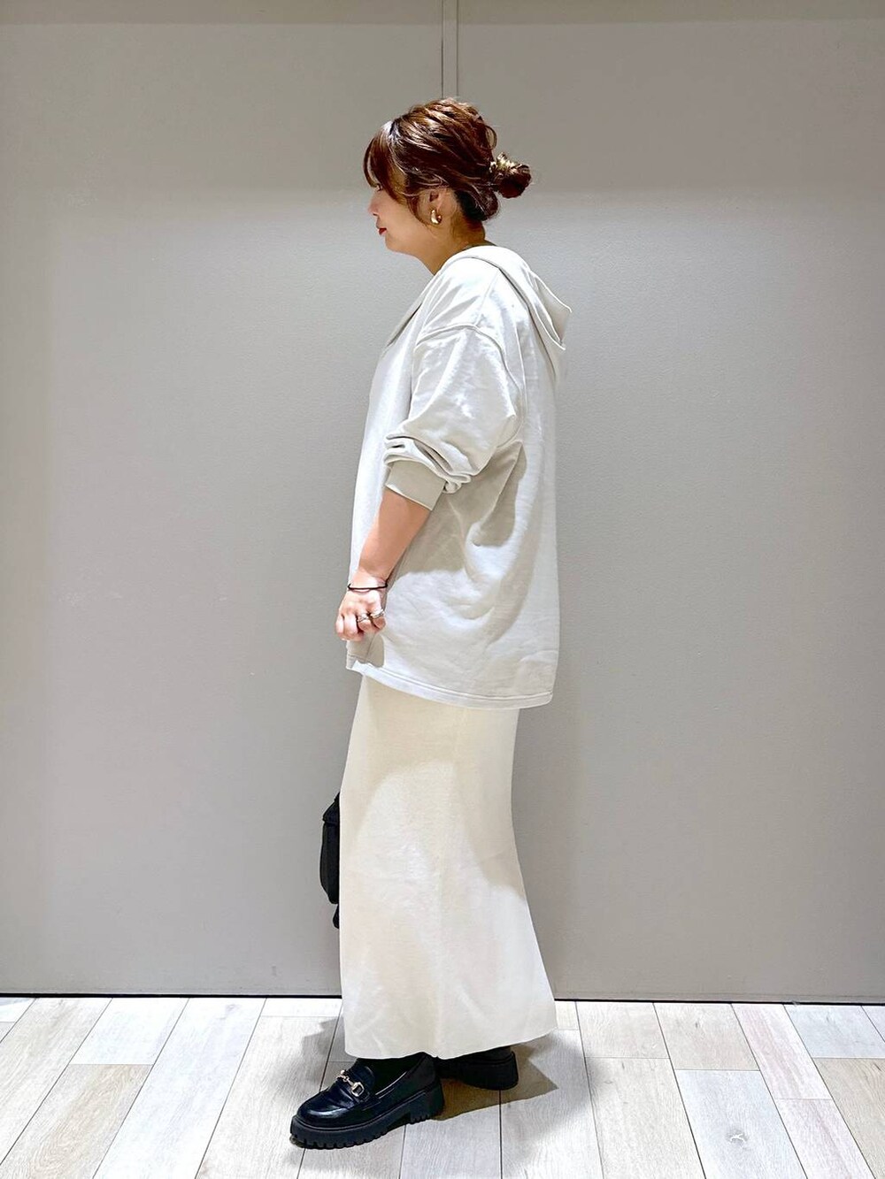 ブラック系のショルダーバッグ、ブラック系のローファー、ホワイト系のスカートを着用したレディースの秋コーディネートの4枚目の写真