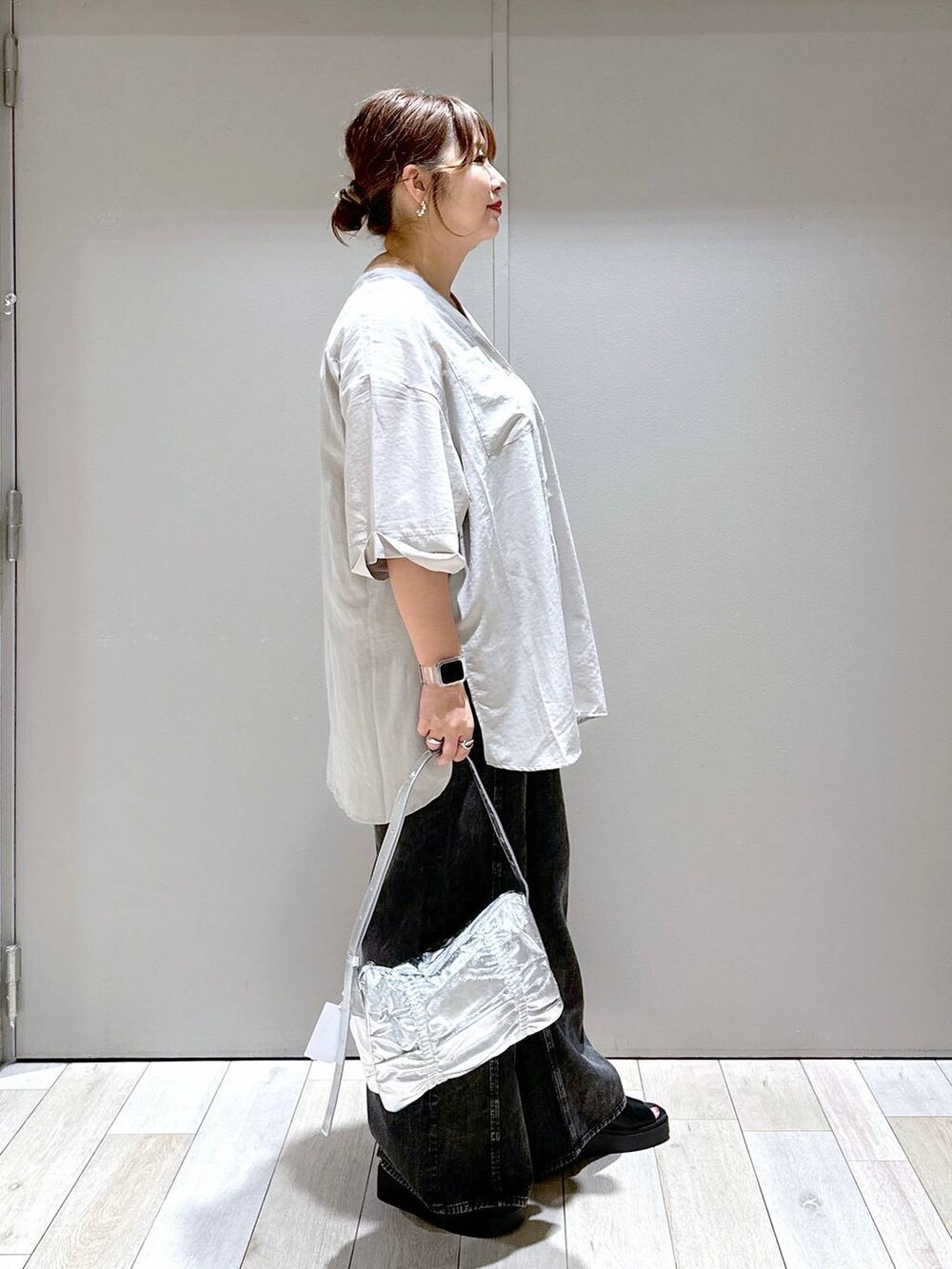 シルバー系のショルダーバッグ、グレー系のワンピース、ブラック系のサンダルを着用したレディースの夏コーディネートの2枚目の写真