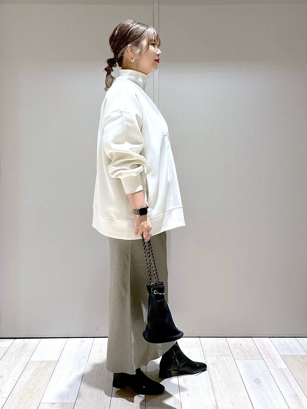 ホワイト系のTシャツ/カットソー、ブラック系のブーツ、グリーン系のスカートを着用したレディースの秋コーディネートの2枚目の写真