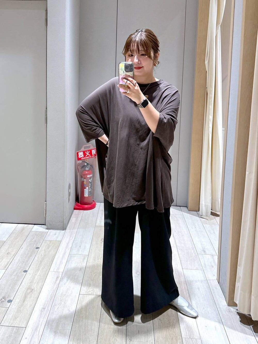 ブラック系のスラックス、シルバー系のパンプス、イエロー系のチュニックを着用したレディースの秋コーディネートの2枚目の写真