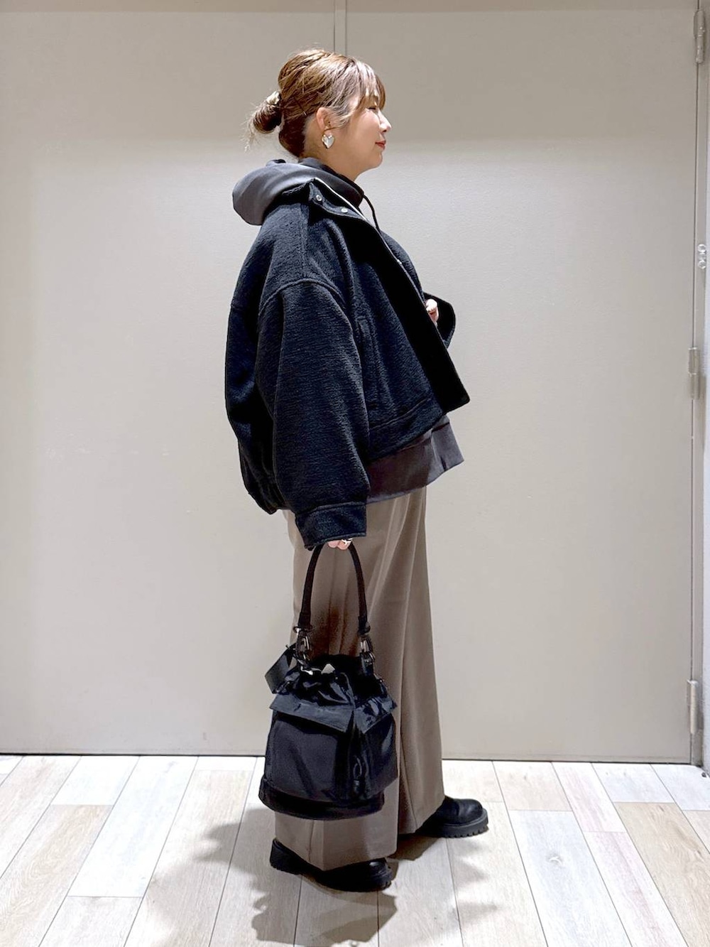 ブラック系のショルダーバッグ、ブラック系のブルゾン、ブラウン系のその他パンツを着用したレディースの冬コーディネートの2枚目の写真