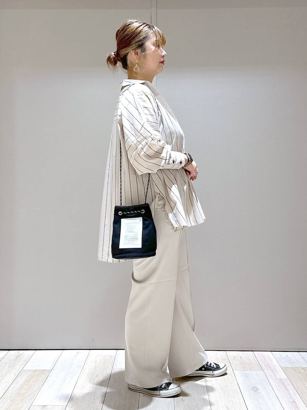 ブラック系のタンクトップ、ベージュ系のスラックス、ベージュ系のシャツ/ブラウスを着用したレディースの夏コーディネートの2枚目の写真