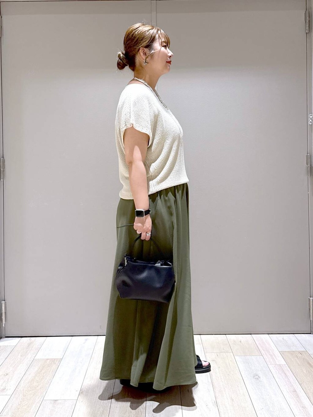 グリーン系のその他パンツ、ホワイト系のニット/セーター、ブラック系のサンダルを着用したレディースの夏コーディネートの2枚目の写真