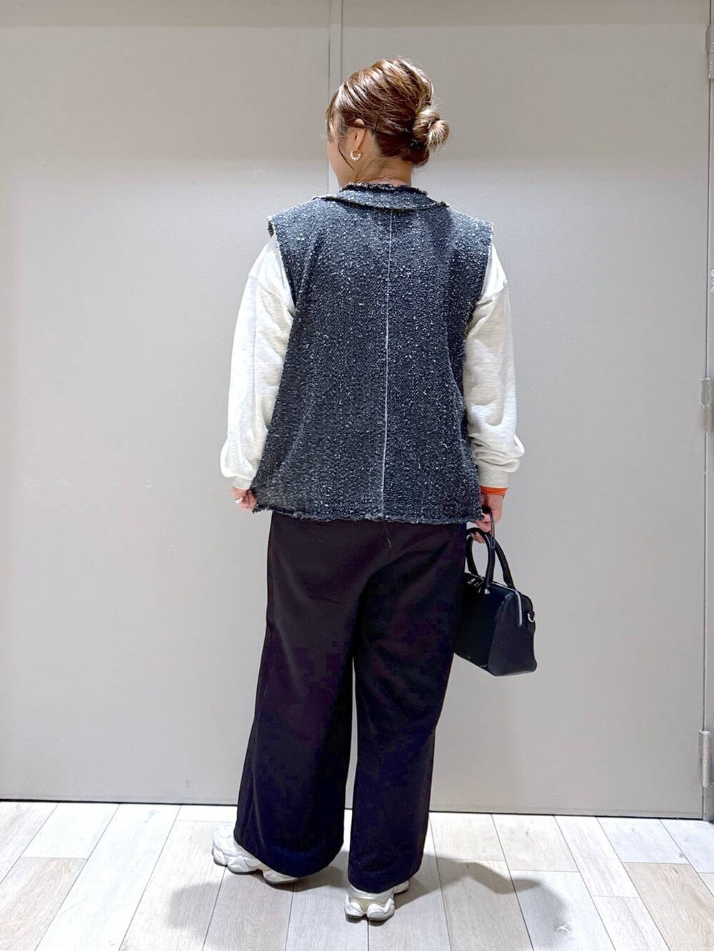 オレンジ系のTシャツ/カットソー、ブラック系のボストンバッグ、ブラック系のその他パンツを着用したレディースの冬コーディネートの3枚目の写真