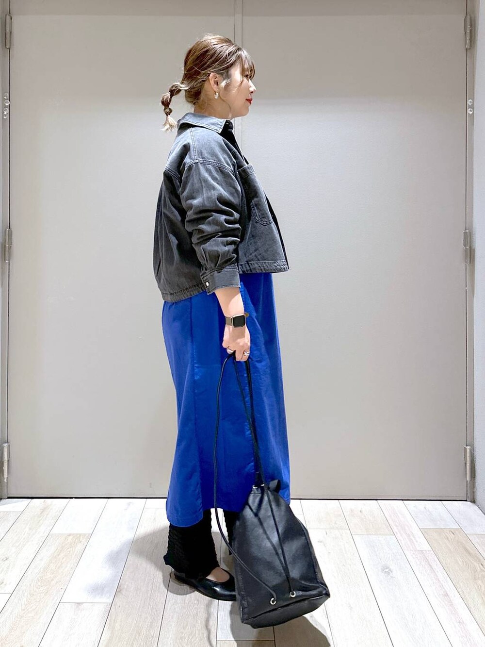 ブラック系のショルダーバッグ、ブルー系のワンピース、ブラック系のパンプスを着用したレディースの春コーディネートの2枚目の写真