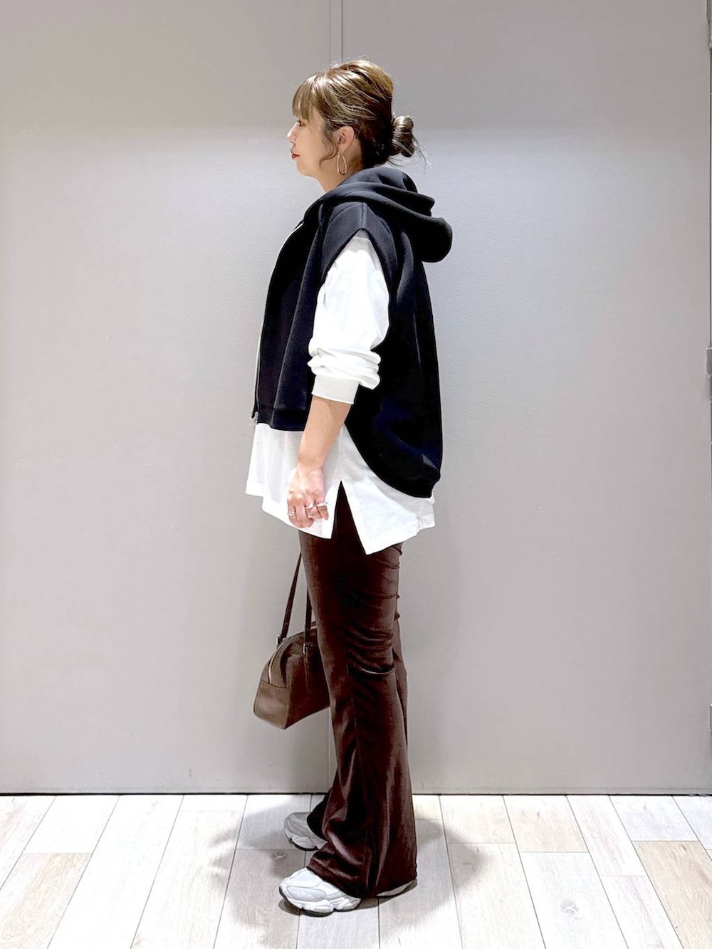 ブラウン系のその他パンツ、ブラウン系のボストンバッグ、ブラック系のベストを着用したレディースの秋コーディネートの4枚目の写真