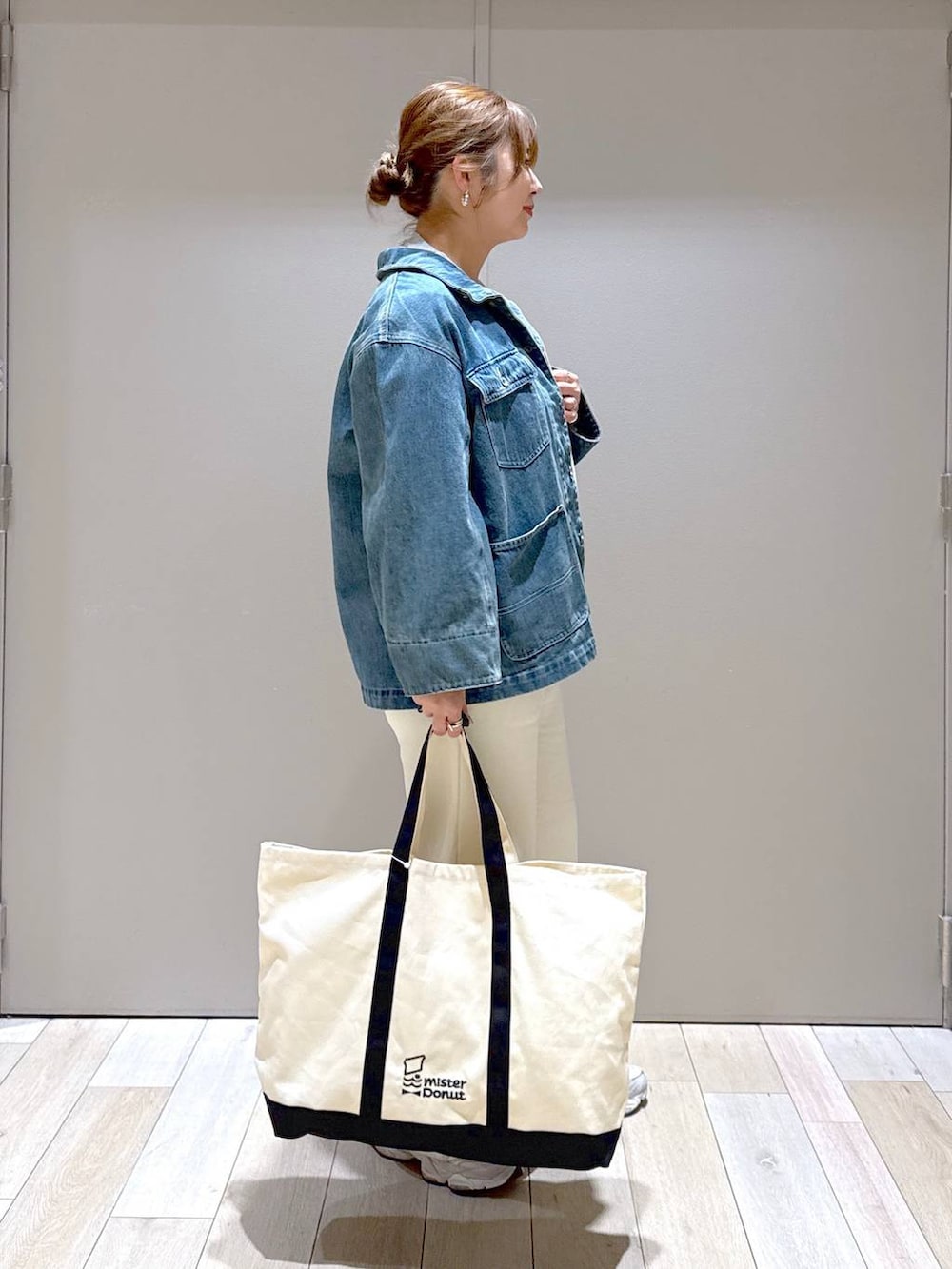 グレー系のTシャツ/カットソー、ホワイト系のトートバッグ、ブルー系のデニムジャケットを着用したレディースの冬コーディネートの2枚目の写真