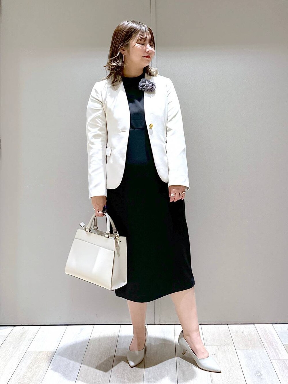 ブラック系のワンピース、ホワイト系のノーカラージャケット、ホワイト系のショルダーバッグを着用したレディースの春コーディネートの5枚目の写真