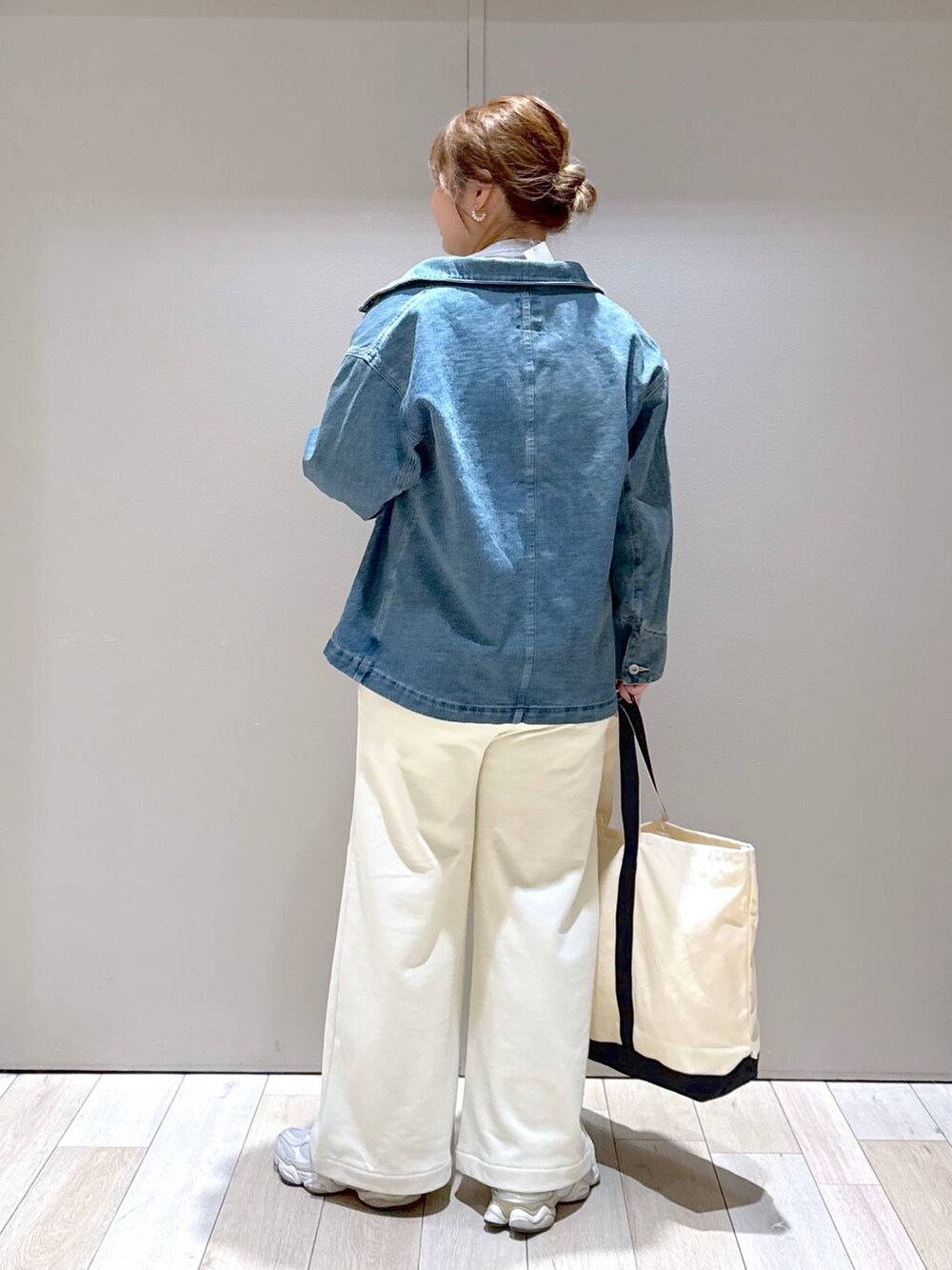 グレー系のTシャツ/カットソー、ホワイト系のトートバッグ、ブルー系のデニムジャケットを着用したレディースの冬コーディネートの3枚目の写真