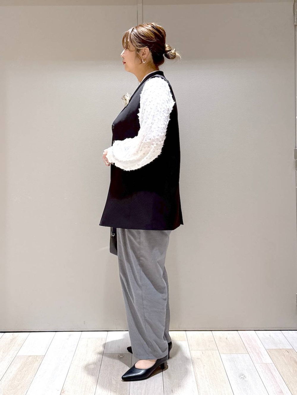 ホワイト系のシャツ/ブラウス、ブラック系のスーツベスト、グレー系のその他パンツを着用したレディースの冬コーディネートの4枚目の写真