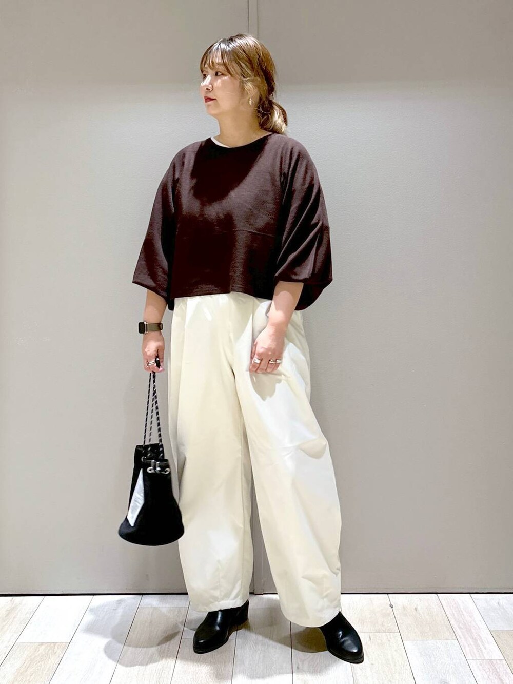 ブラウン系のニット/セーター、ブラック系のブーツ、ホワイト系のその他パンツを着用したレディースの秋コーディネートの3枚目の写真