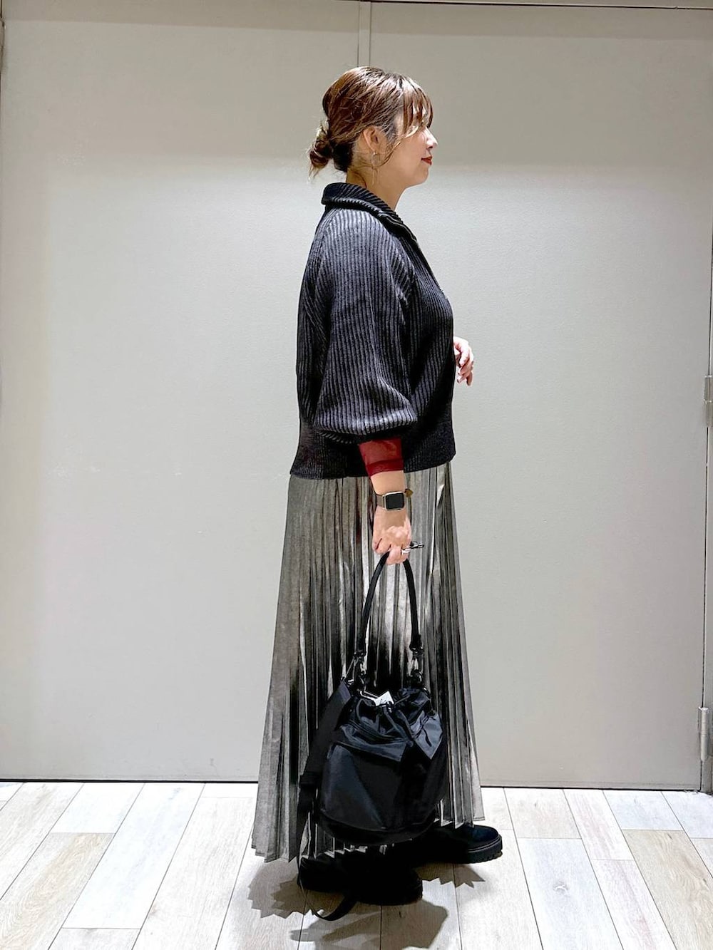 ブラック系のショルダーバッグ、ブラック系のカーディガン/ボレロ、ブラック系のブーツを着用したレディースの秋コーディネートの2枚目の写真