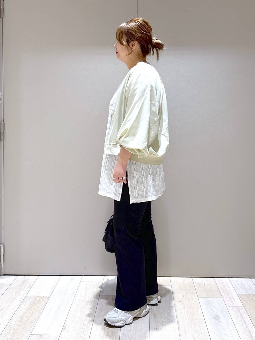 ブラック系のショルダーバッグ、ブラック系のスラックス、グリーン系のブルゾンを着用したレディースの春コーディネートの4枚目の写真