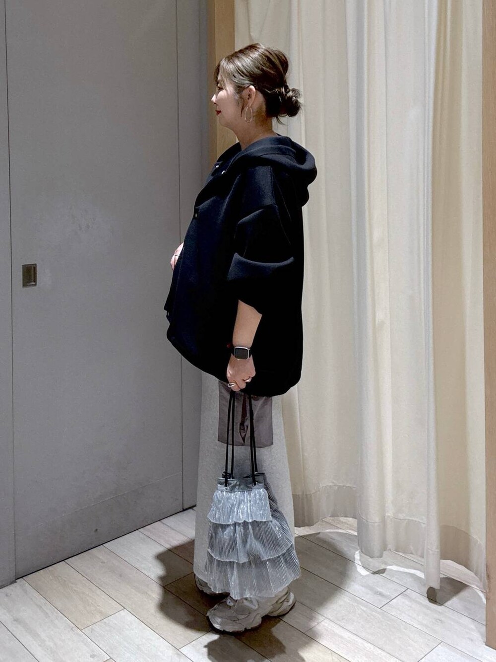 ブラック系のブルゾン、グレー系のスカート、シルバー系のショルダーバッグを着用したレディースの秋コーディネートの4枚目の写真