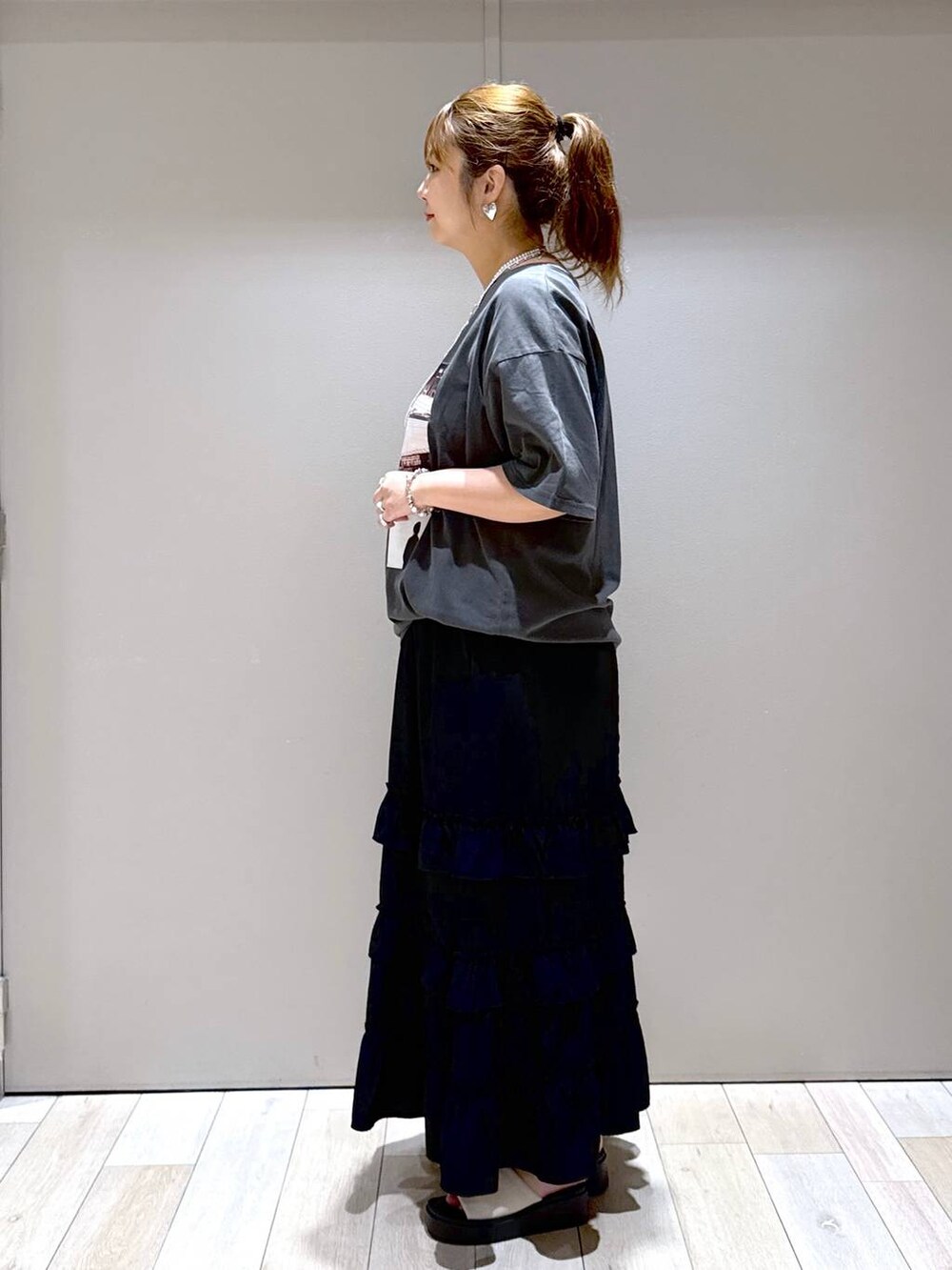 ホワイト系のサンダル、ブラック系のスカート、グレー系のTシャツ/カットソーを着用したレディースの夏コーディネートの4枚目の写真