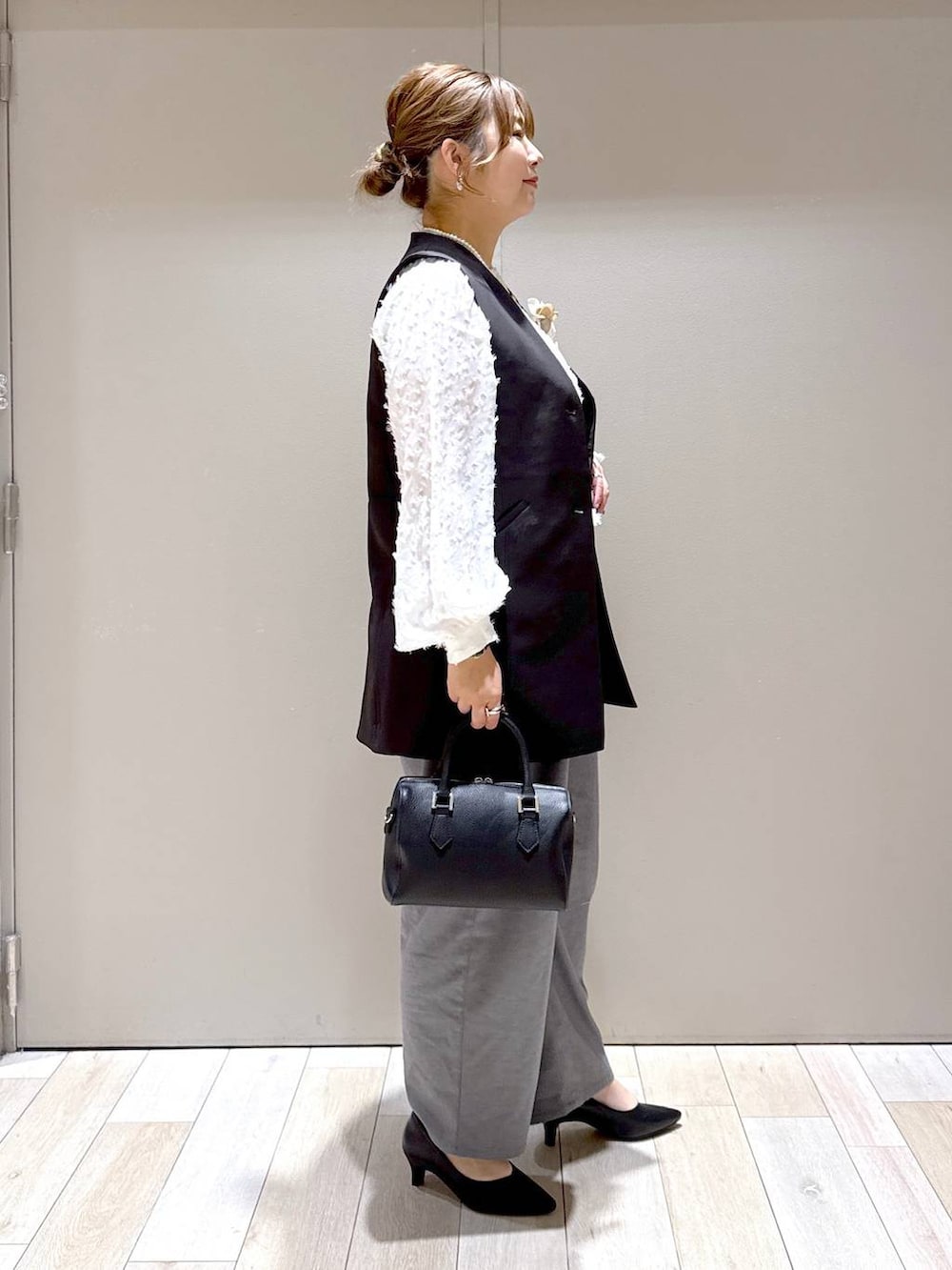 ホワイト系のシャツ/ブラウス、ブラック系のスーツベスト、グレー系のその他パンツを着用したレディースの冬コーディネートの2枚目の写真