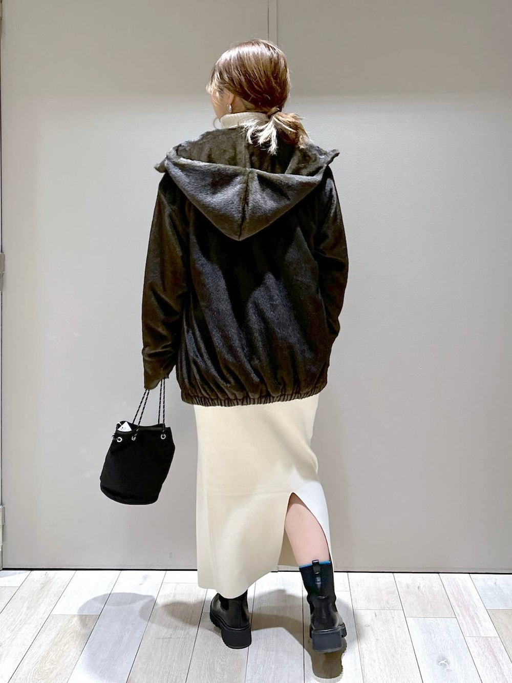 ホワイト系のニット/セーター、ホワイト系のスカート、グリーン系のブルゾンを着用したレディースの冬コーディネートの3枚目の写真