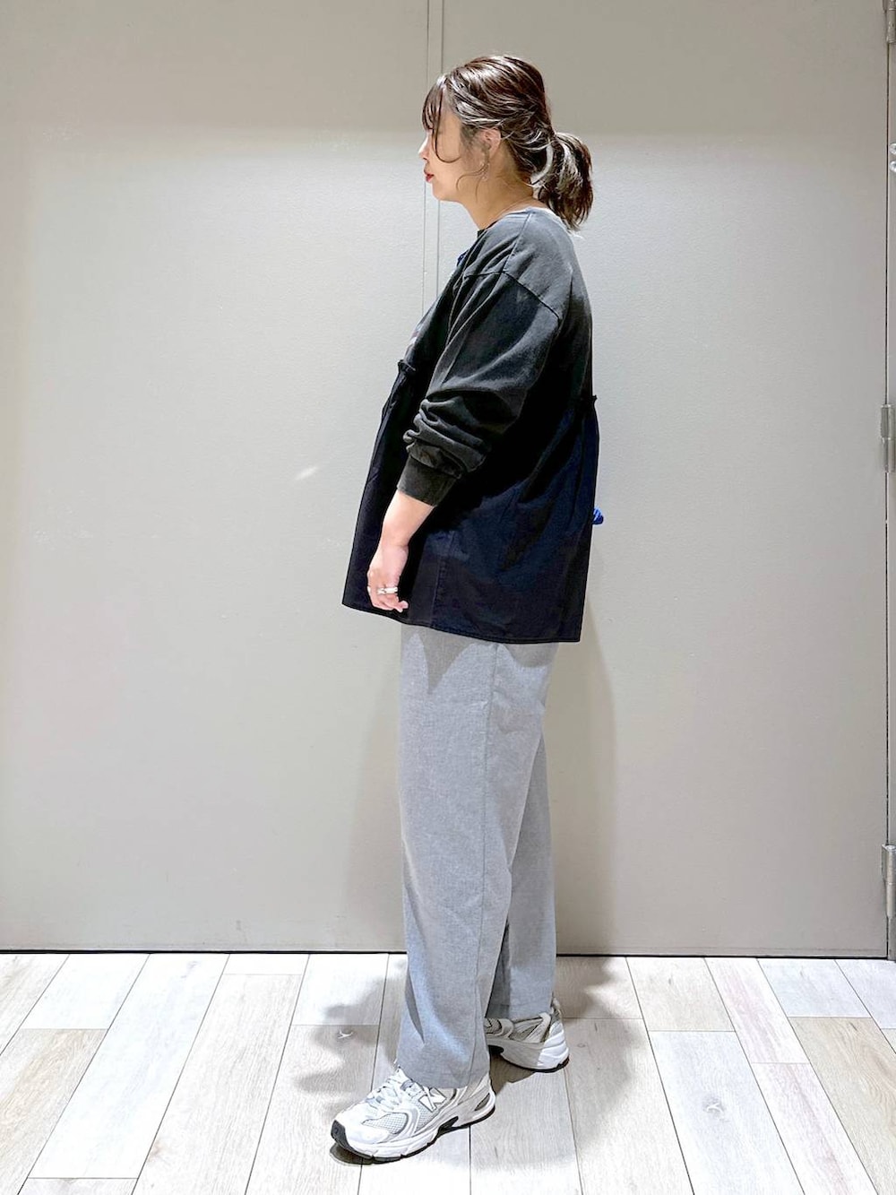 ブルー系のトートバッグ、グレー系のスラックス、グレー系のTシャツ/カットソーを着用したレディースの冬コーディネートの4枚目の写真