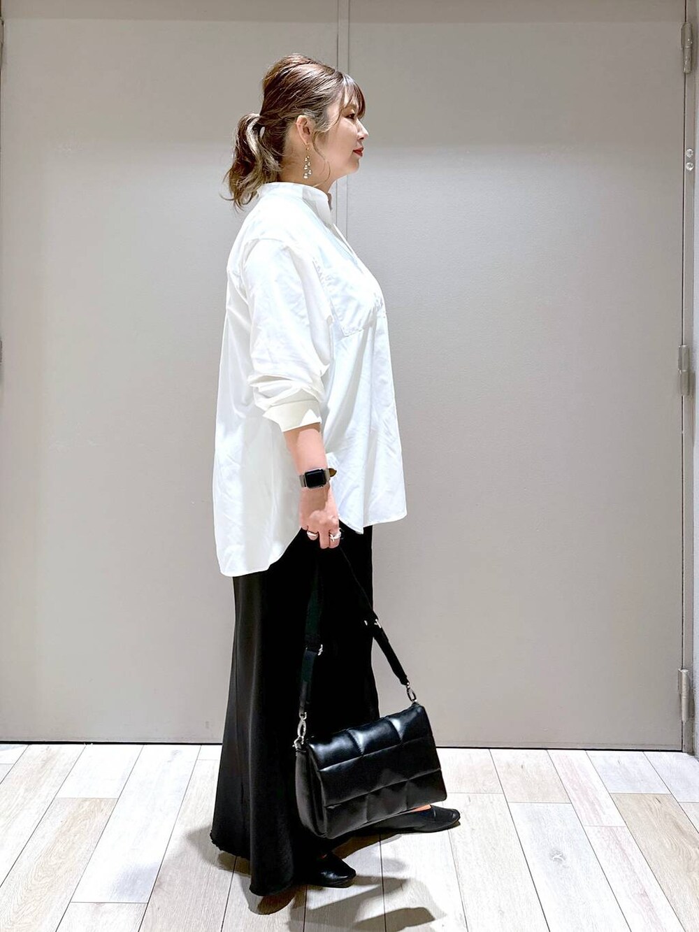 ブラック系のショルダーバッグ、ブラック系のパンプス、ブラック系のスカートを着用したレディースの春コーディネートの2枚目の写真