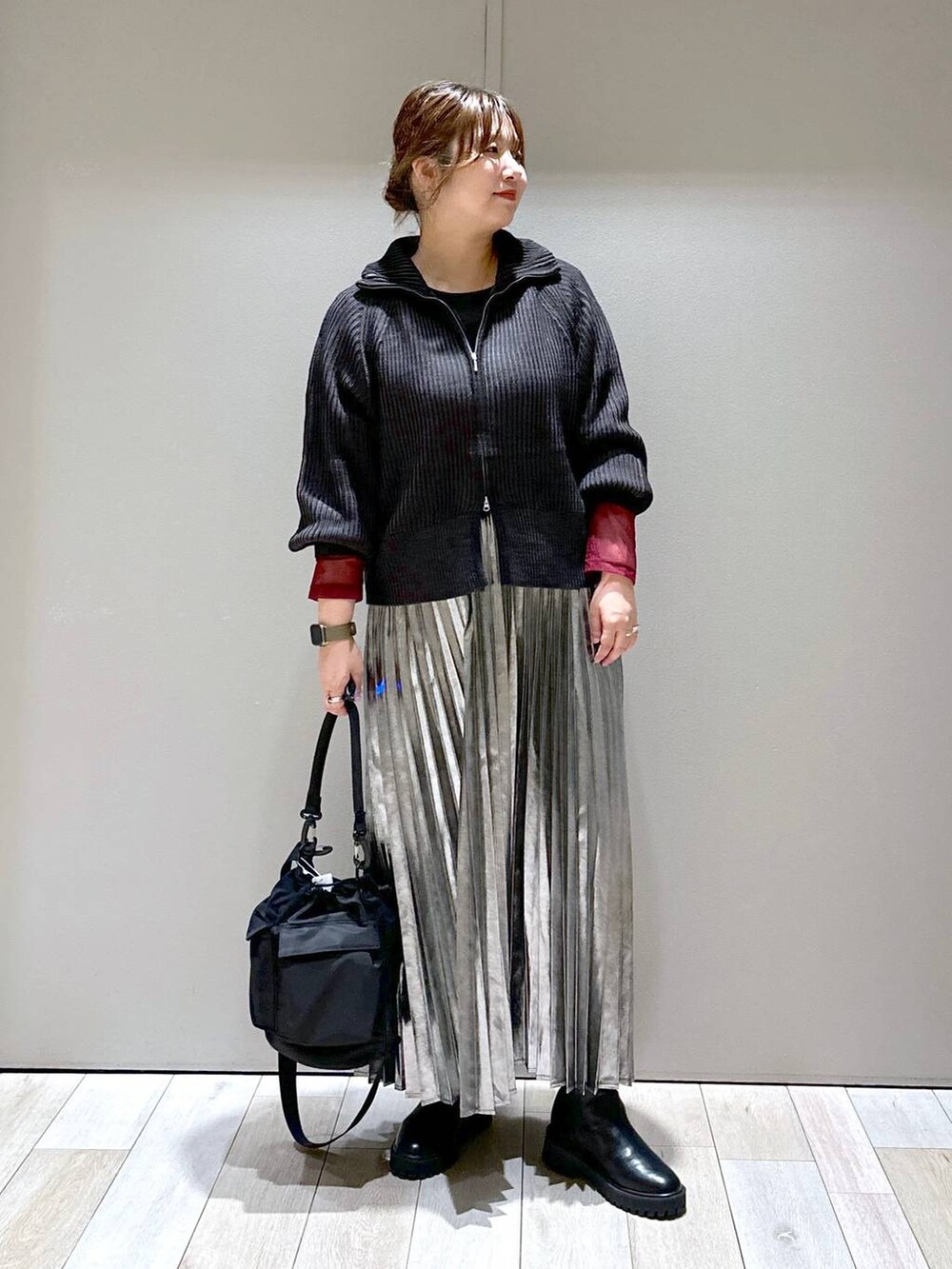 ブラック系のショルダーバッグ、ブラック系のカーディガン/ボレロ、ブラック系のブーツを着用したレディースの秋コーディネートの5枚目の写真