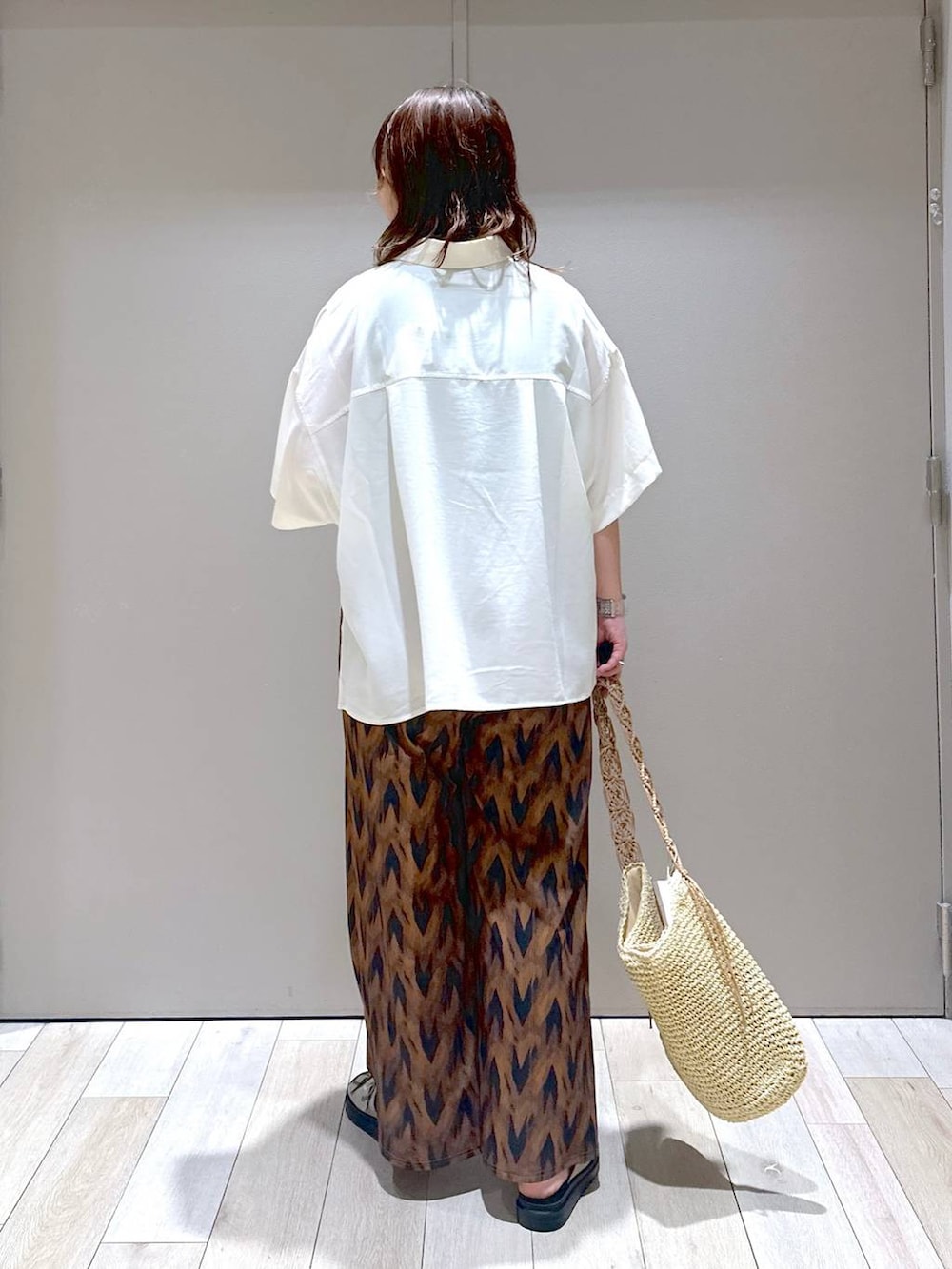 ベージュ系のショルダーバッグ、ホワイト系のシャツ/ブラウス、ベージュ系のサンダルを着用したレディースの夏コーディネートの3枚目の写真