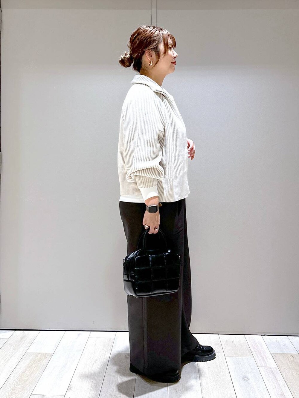 ブラック系のローファー、ホワイト系のカーディガン/ボレロ、ブラック系のボストンバッグを着用したレディースの秋コーディネートの2枚目の写真