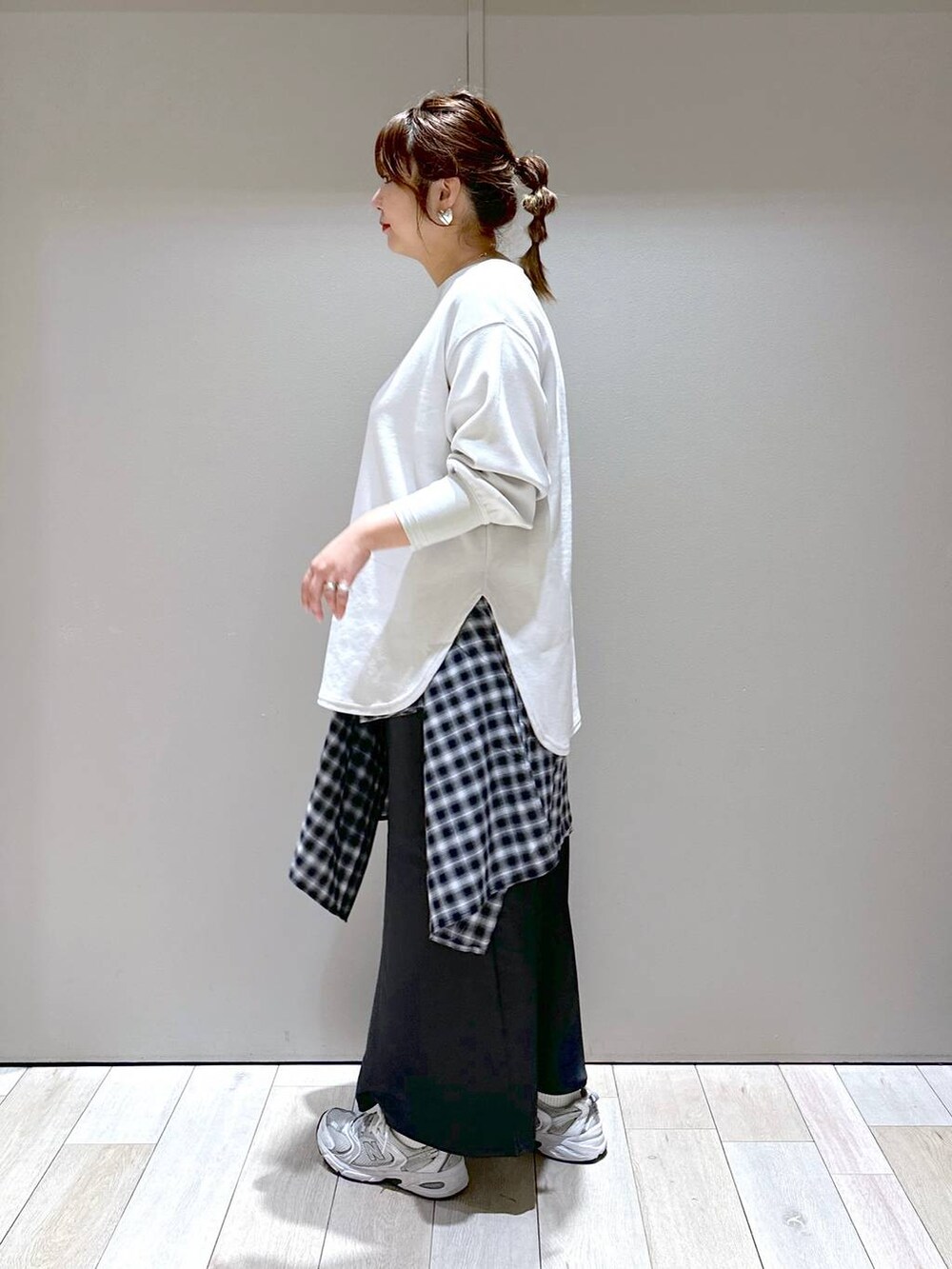 ベージュ系のTシャツ/カットソー、シルバー系のボストンバッグ、ブラック系のスカートを着用したレディースの秋コーディネートの5枚目の写真