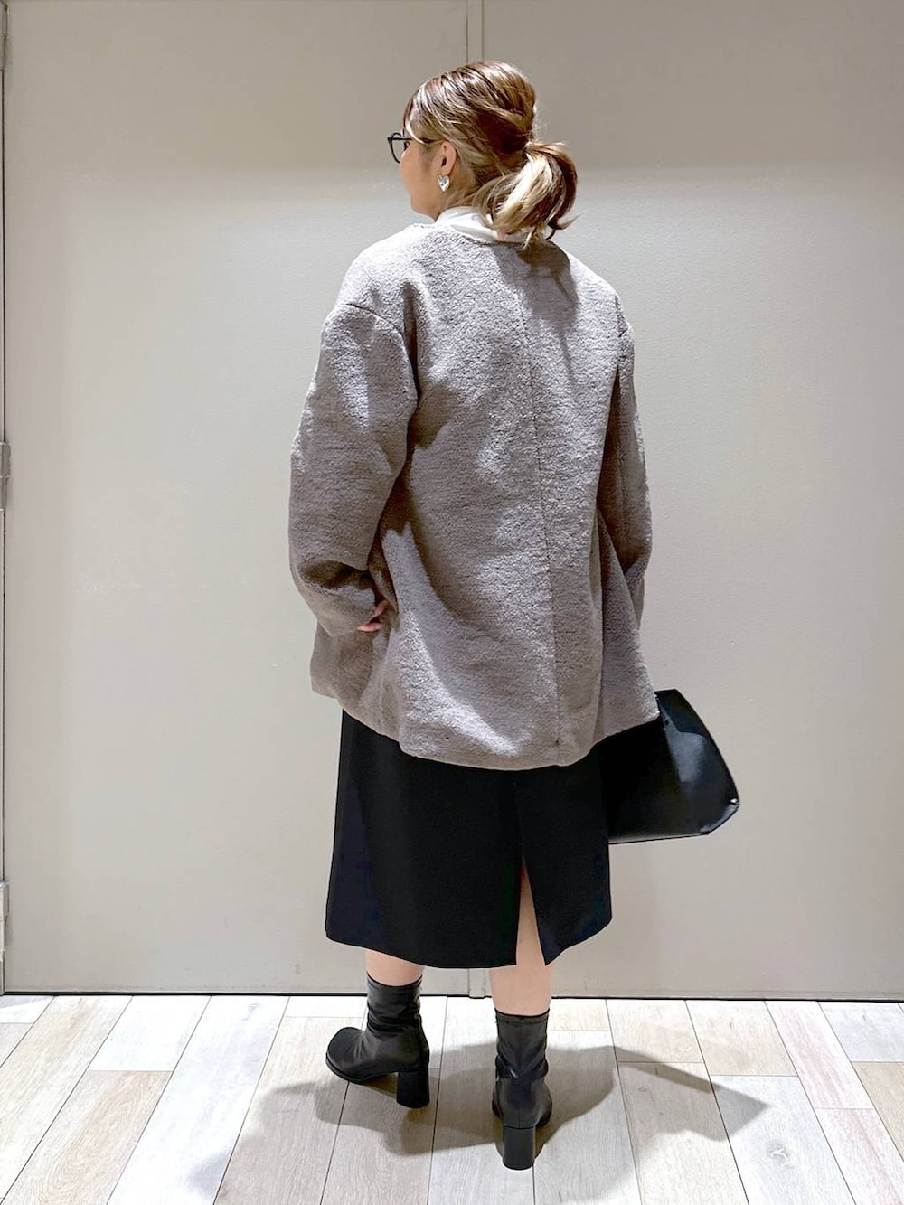 ブラウン系のノーカラーコート、ブラック系のブーツ、ホワイト系のシャツ/ブラウスを着用したレディースの冬コーディネートの4枚目の写真