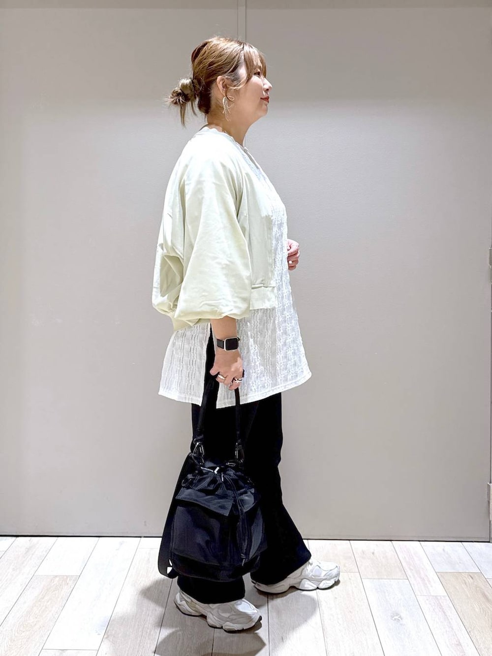 ブラック系のショルダーバッグ、ブラック系のスラックス、グリーン系のブルゾンを着用したレディースの春コーディネートの2枚目の写真