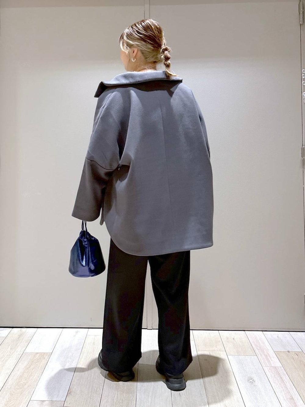 グレー系のポンチョ、ブラック系のその他パンツ、ブラック系のブーツを着用したレディースの冬コーディネートの3枚目の写真