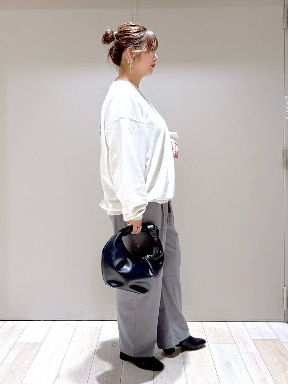 ブラック系のブーツ、グレー系のその他パンツ、ベージュ系のスウェットを着用したレディースの冬コーディネートの2枚目の写真