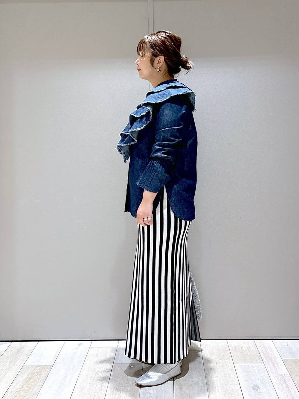 シルバー系のショルダーバッグ、シルバー系のパンプス、ブラック系のスカートを着用したレディースの秋コーディネートの4枚目の写真