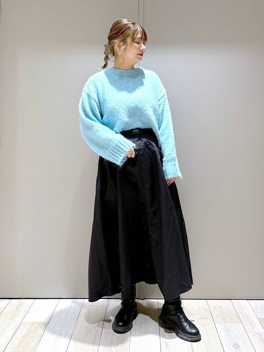 ブラック系のショルダーバッグ、ブラック系のブーツ、ブラック系のスカートを着用したレディースの冬コーディネートの7枚目の写真