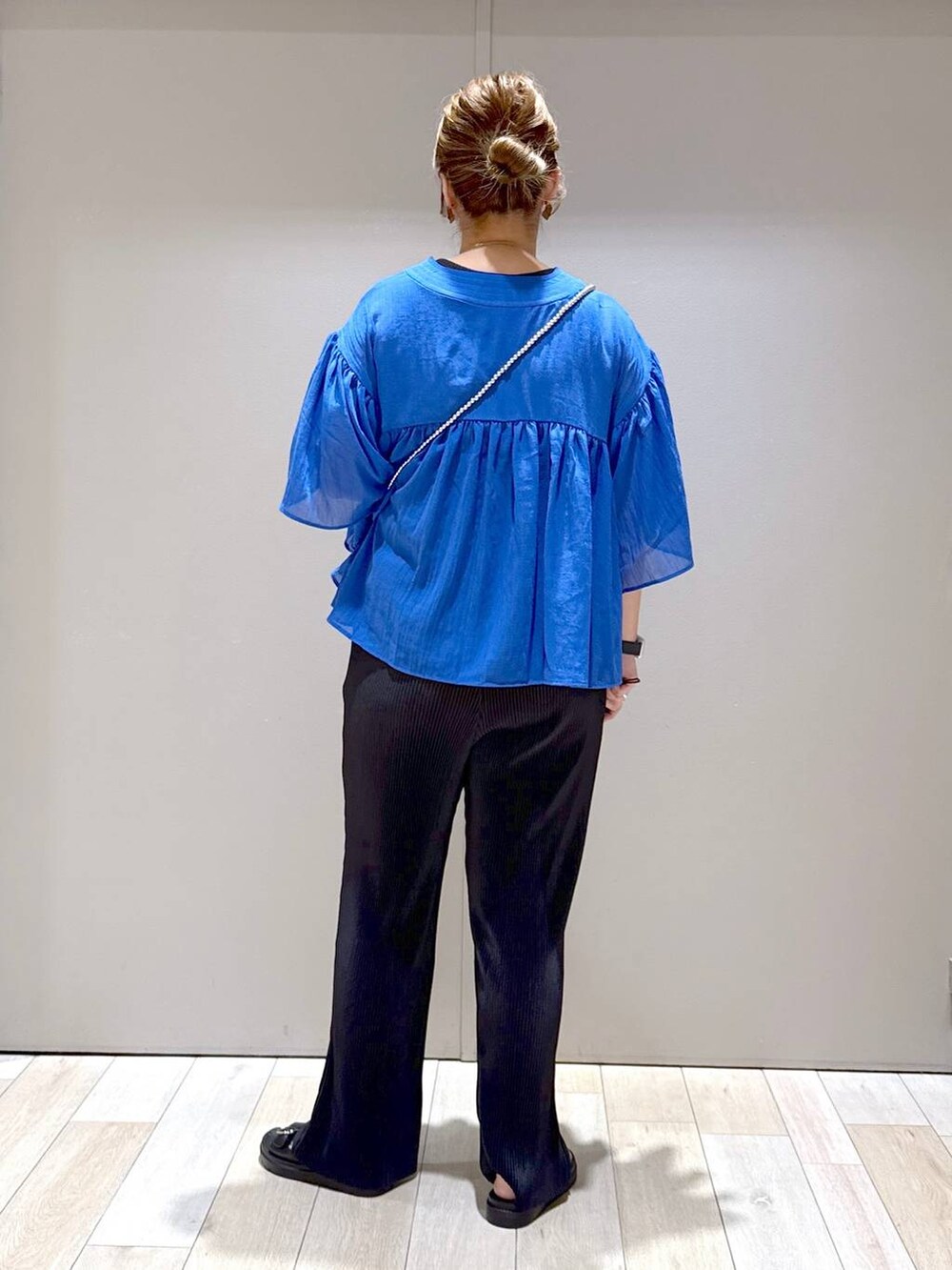 ブルー系のシャツ/ブラウス、ブラック系のTシャツ/カットソー、ブラック系のサンダルを着用したレディースの春コーディネートの3枚目の写真