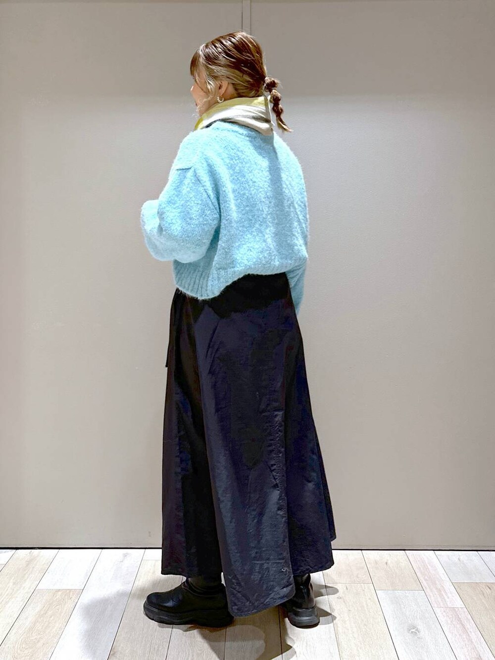 ブラック系のショルダーバッグ、ブラック系のブーツ、ブラック系のスカートを着用したレディースの冬コーディネートの4枚目の写真