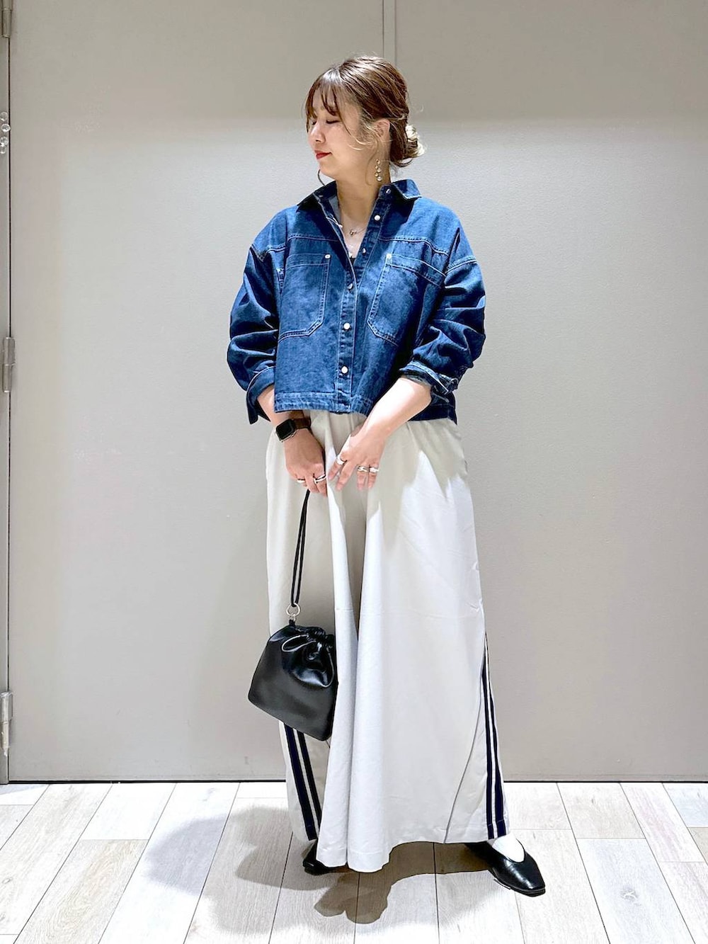 ブラック系のショルダーバッグ、ブラック系のパンプス、ブルー系のシャツ/ブラウスを着用したレディースの春コーディネートの5枚目の写真