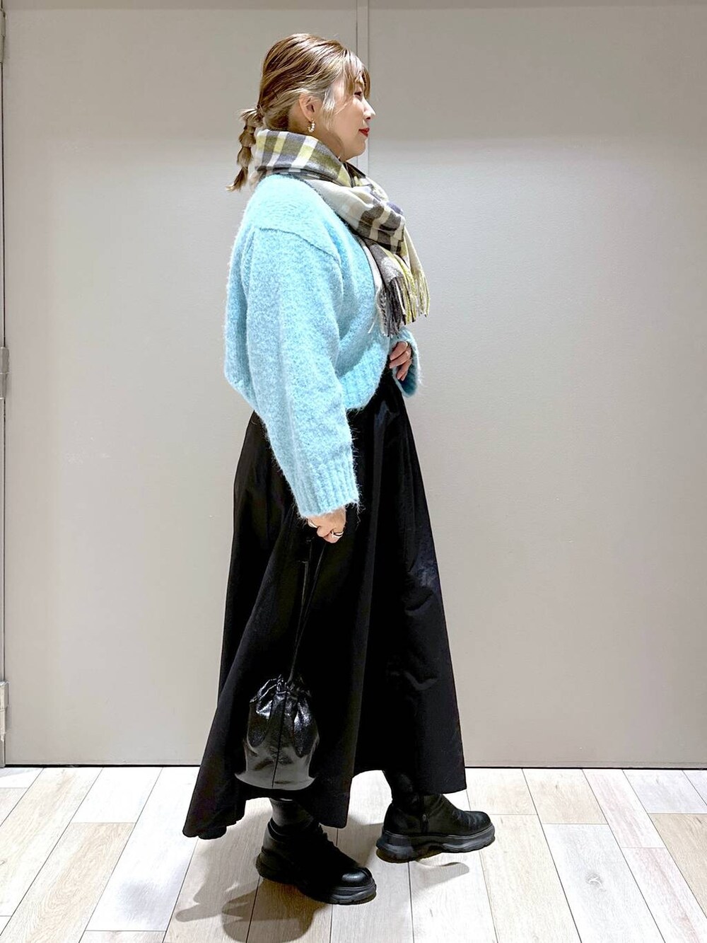 ブラック系のショルダーバッグ、ブラック系のブーツ、ブラック系のスカートを着用したレディースの冬コーディネートの3枚目の写真