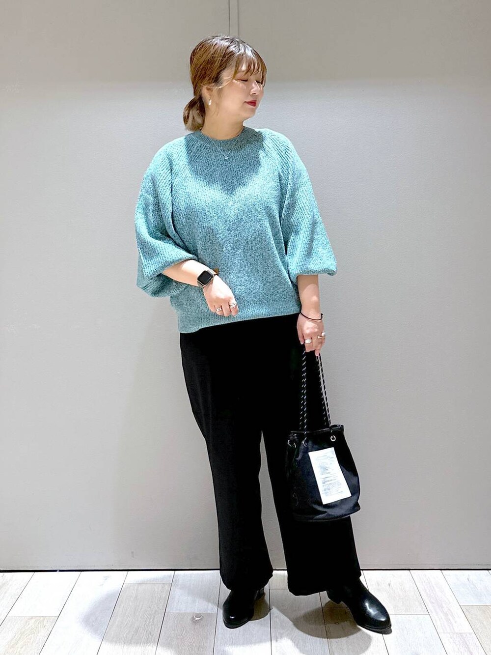 ブラック系のブーツ、ブラック系のその他パンツ、グリーン系のニット/セーターを着用したレディースの秋コーディネートの4枚目の写真