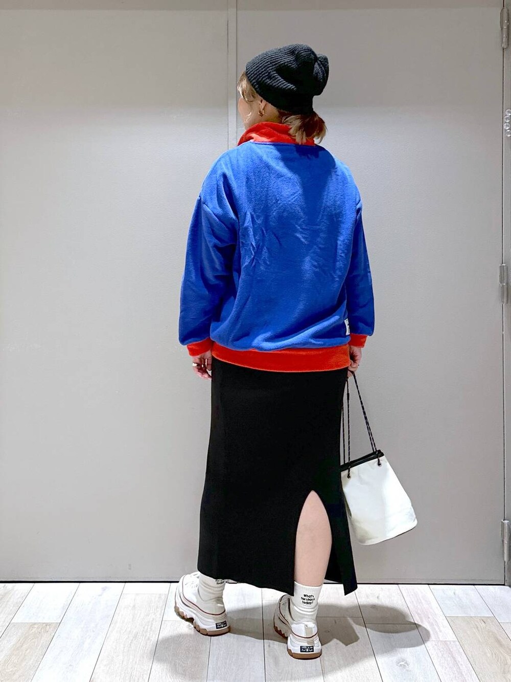 ブラック系のスカート、ブルー系のTシャツ/カットソー、ブラック系のニットキャップ/ビーニーを着用したレディースの秋コーディネートの3枚目の写真