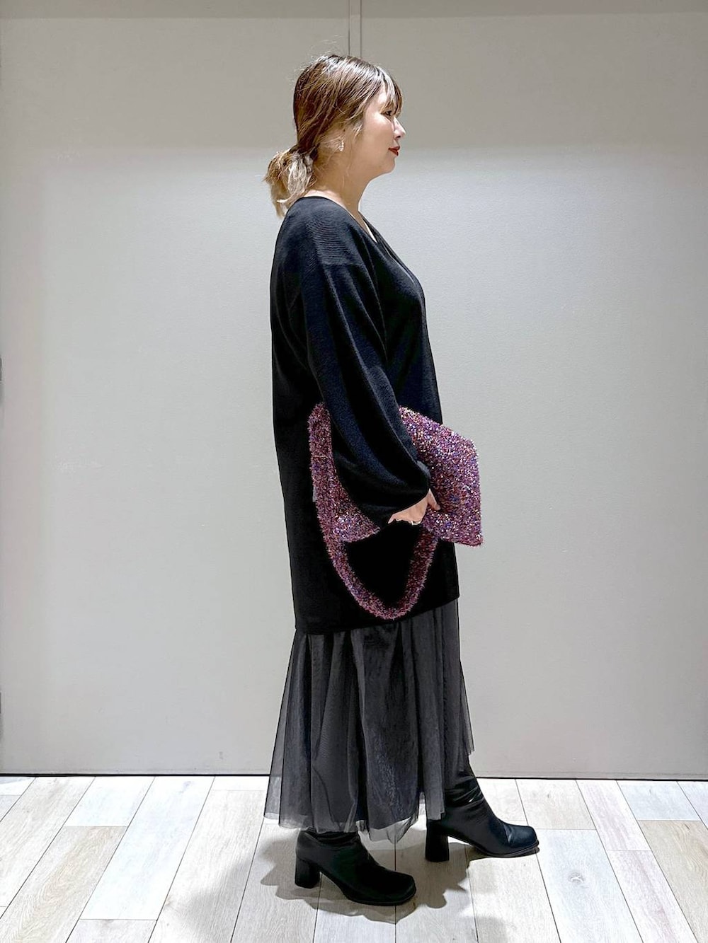 ブラック系のチュニック、ブラック系のブーツ、その他のショルダーバッグを着用したレディースの秋コーディネートの2枚目の写真