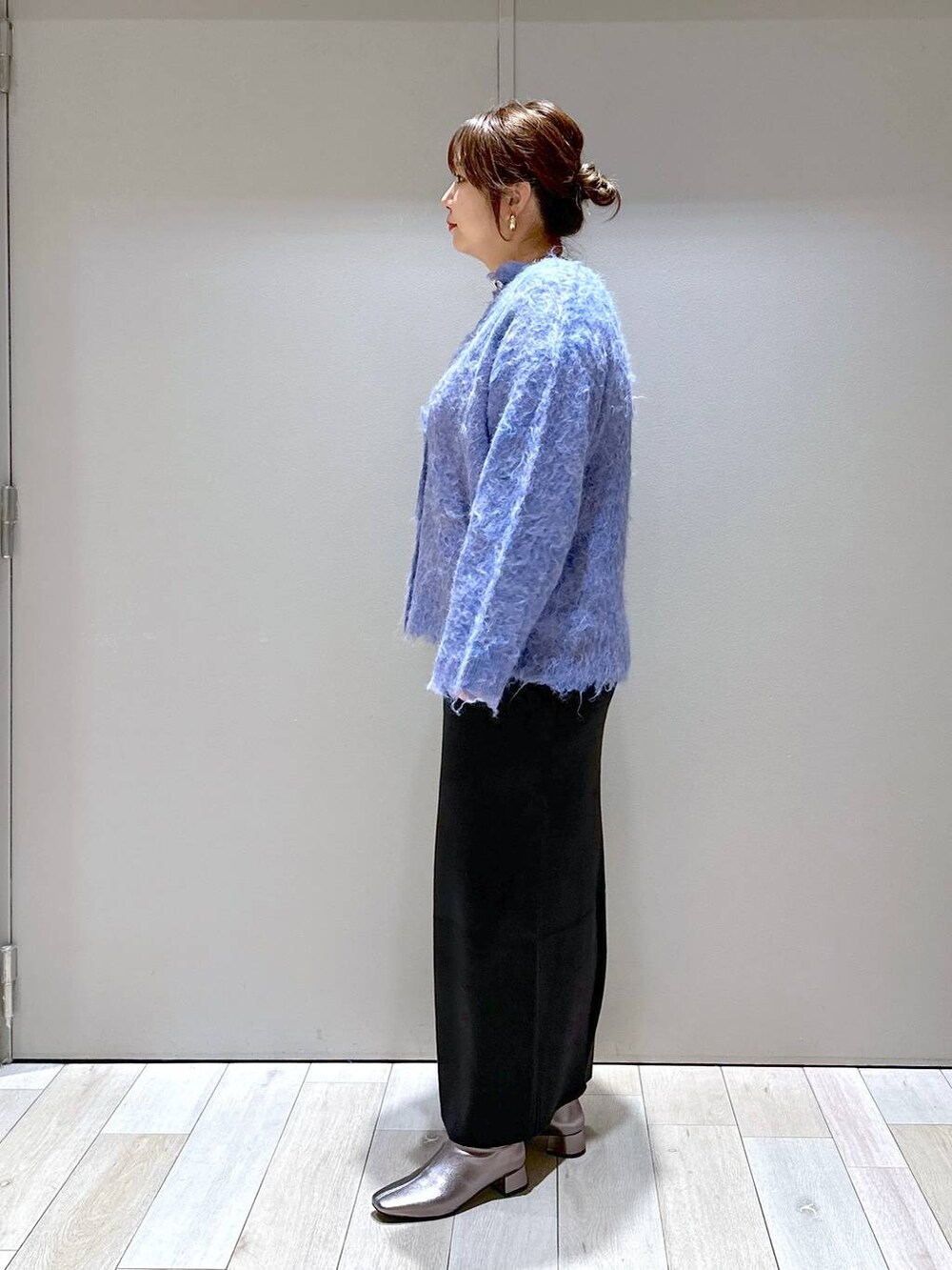 ブラック系のショルダーバッグ、ブラック系のスカート、ブルー系のカーディガン/ボレロを着用したレディースの秋コーディネートの4枚目の写真