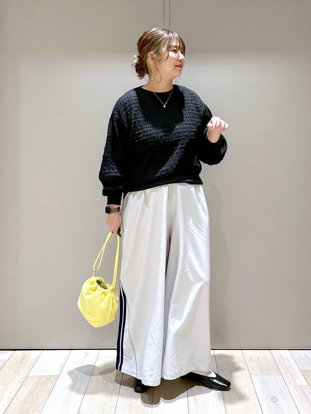 ブラック系のTシャツ/カットソー、ブラック系のパンプス、イエロー系のショルダーバッグを着用したレディースの春コーディネートの4枚目の写真