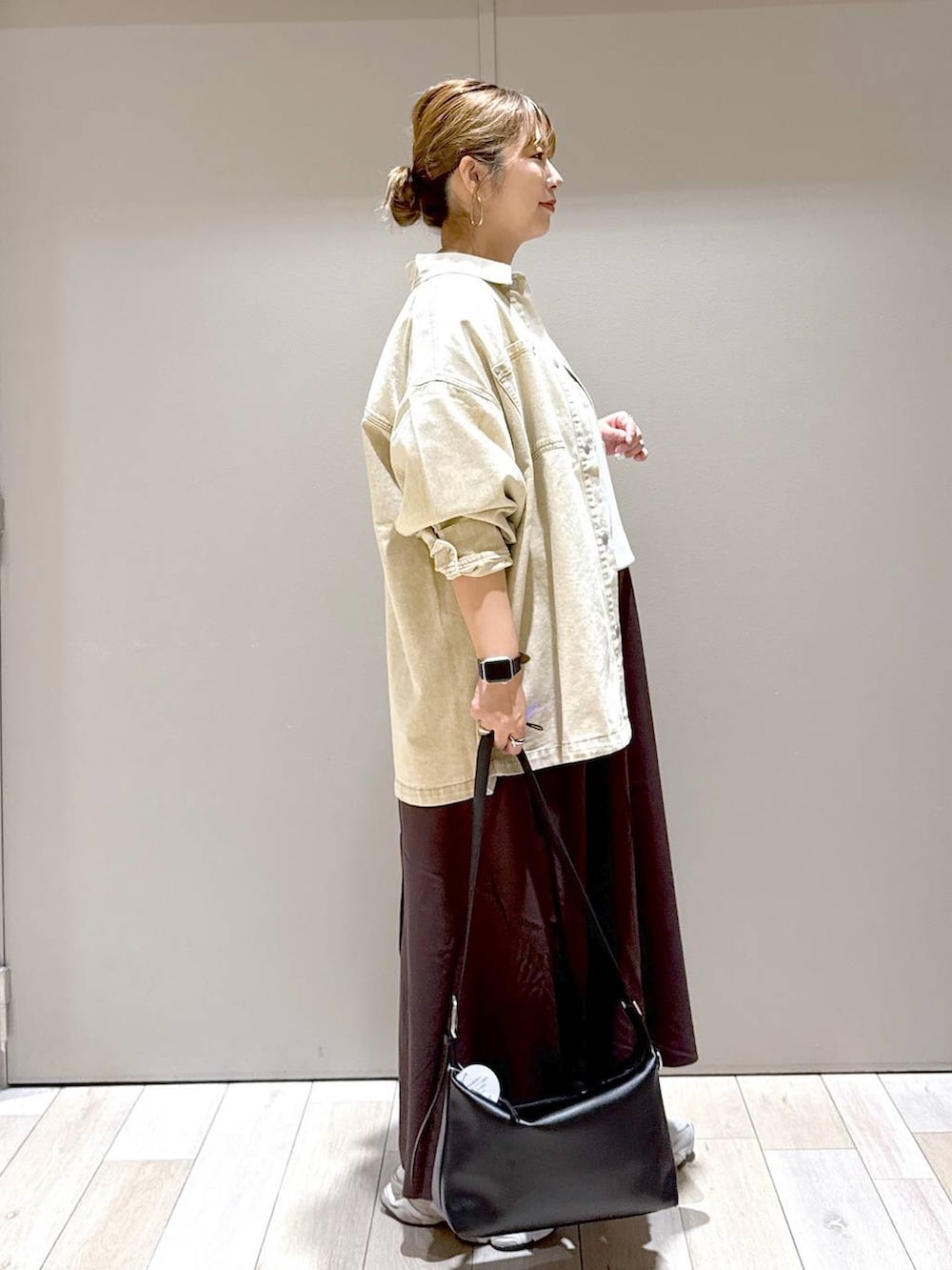 ブラック系のショルダーバッグ、ベージュ系のシャツ/ブラウス、ブラウン系のスカートを着用したレディースの秋コーディネートの2枚目の写真